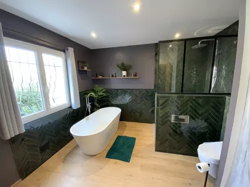 Salle de bain avec baignoire îlot et douche carrelée en zellige vert