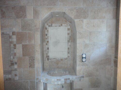 Mur de douche carrelé avec niche et frise en mosaïque